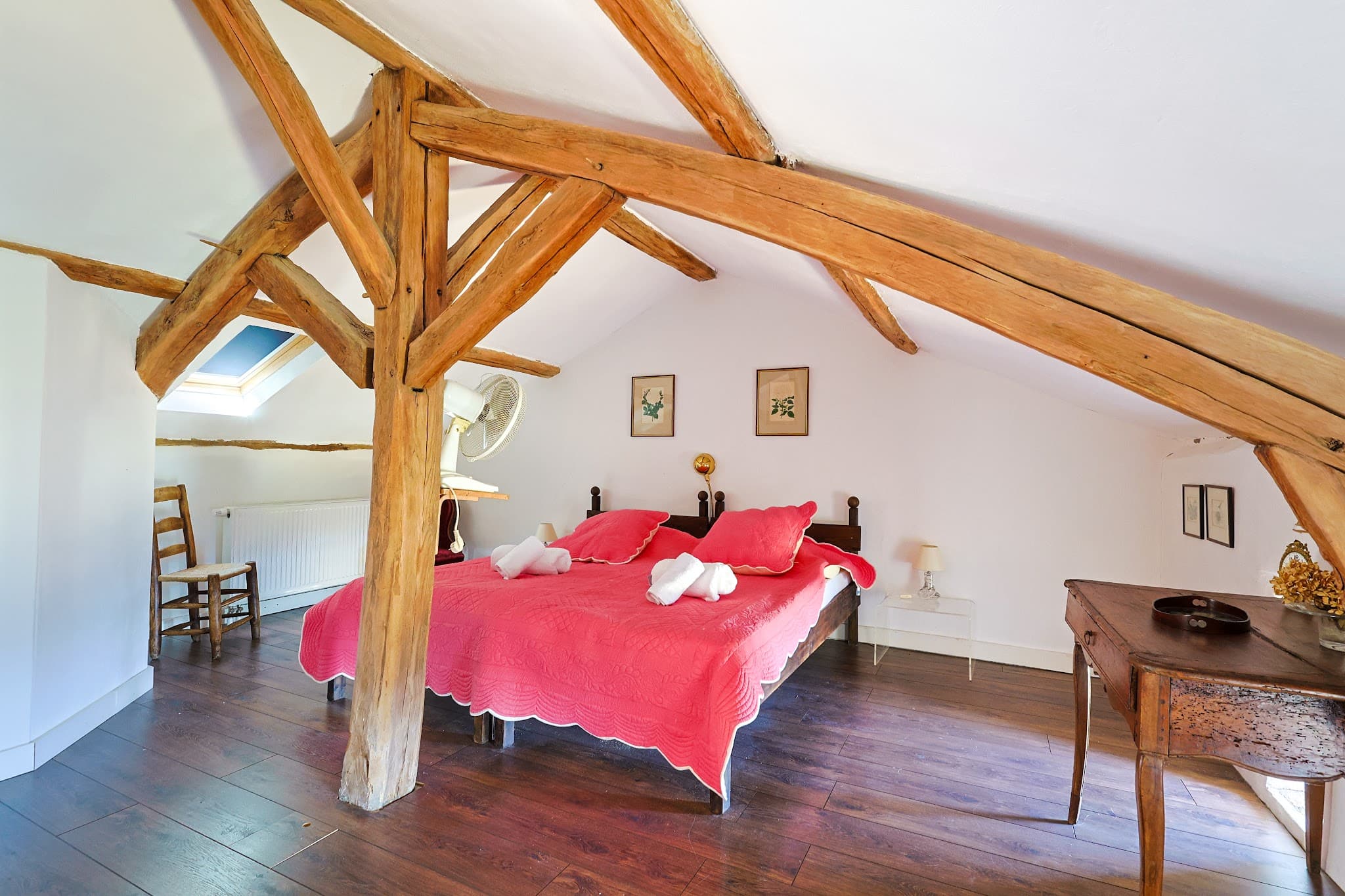 The main bedroom at The Friends' House, beneath the exposed roof timbers.