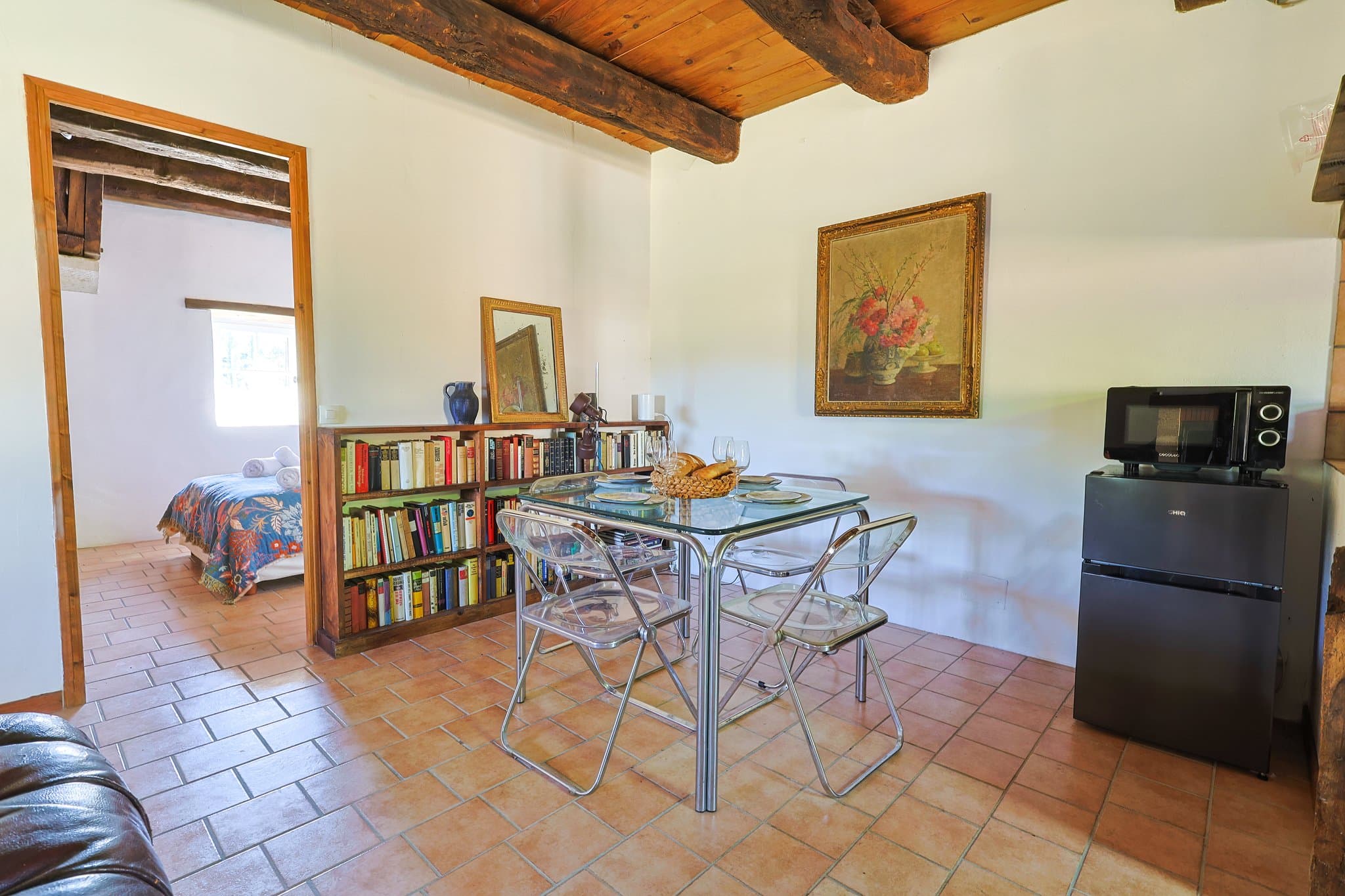 The dining corner at Andrea's House, its bookshelves opening onto the bedroom.