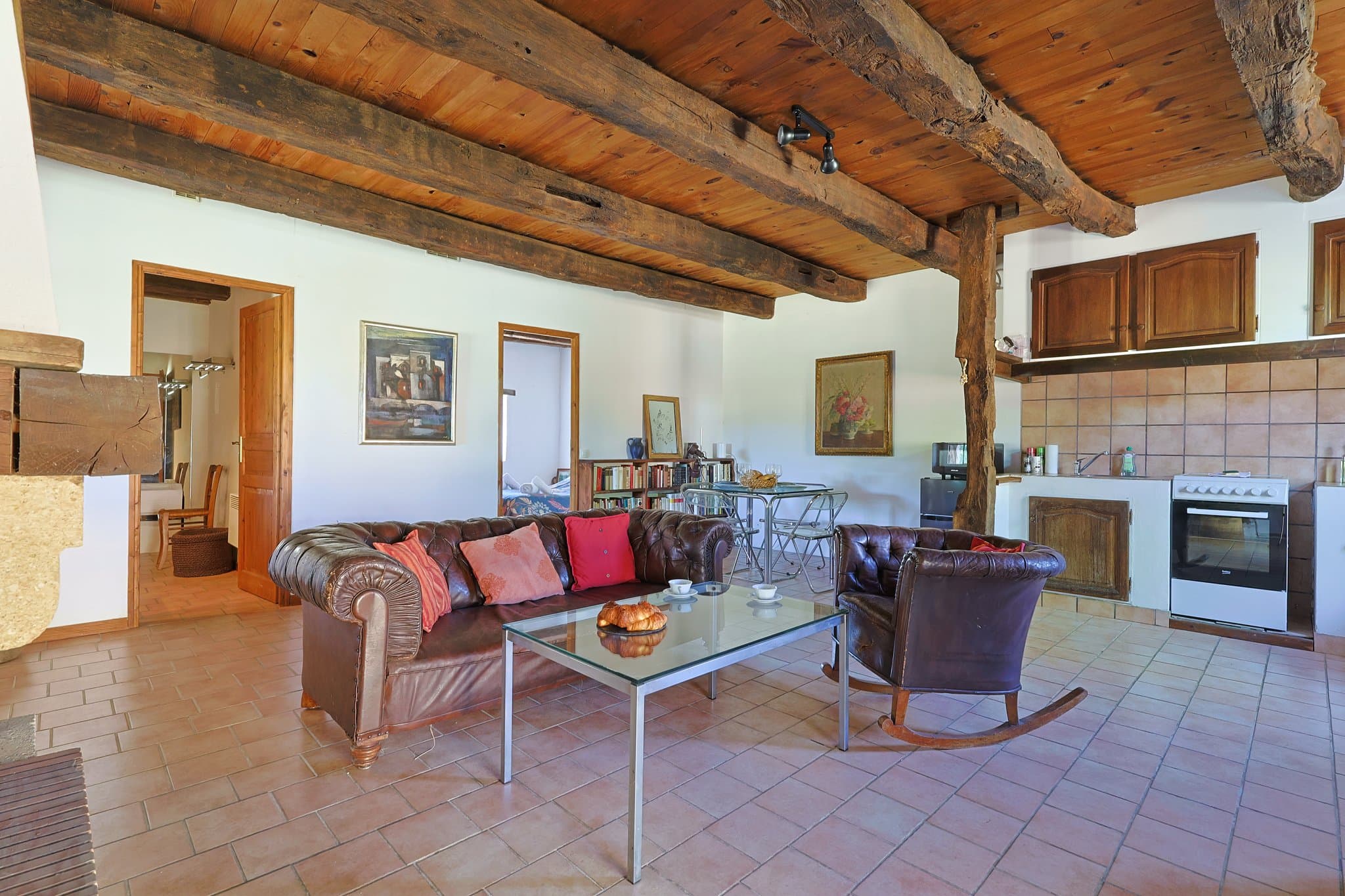 The living room at Andrea's House, with its leather sofas and fireplace, opening onto the kitchen.