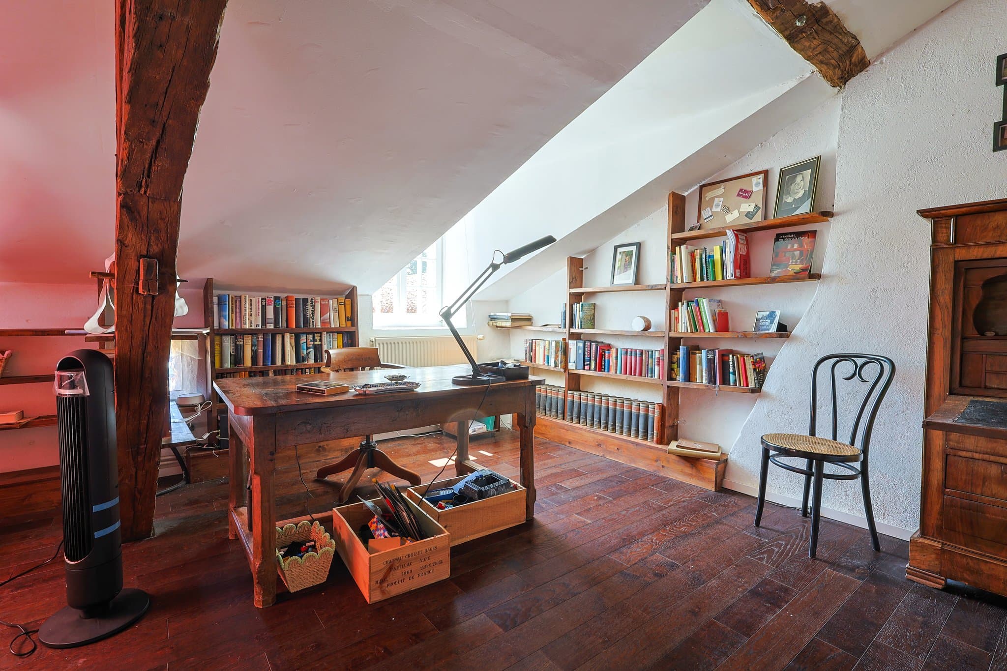 The first-floor desk and library corner at Chez Momône, under the eaves.