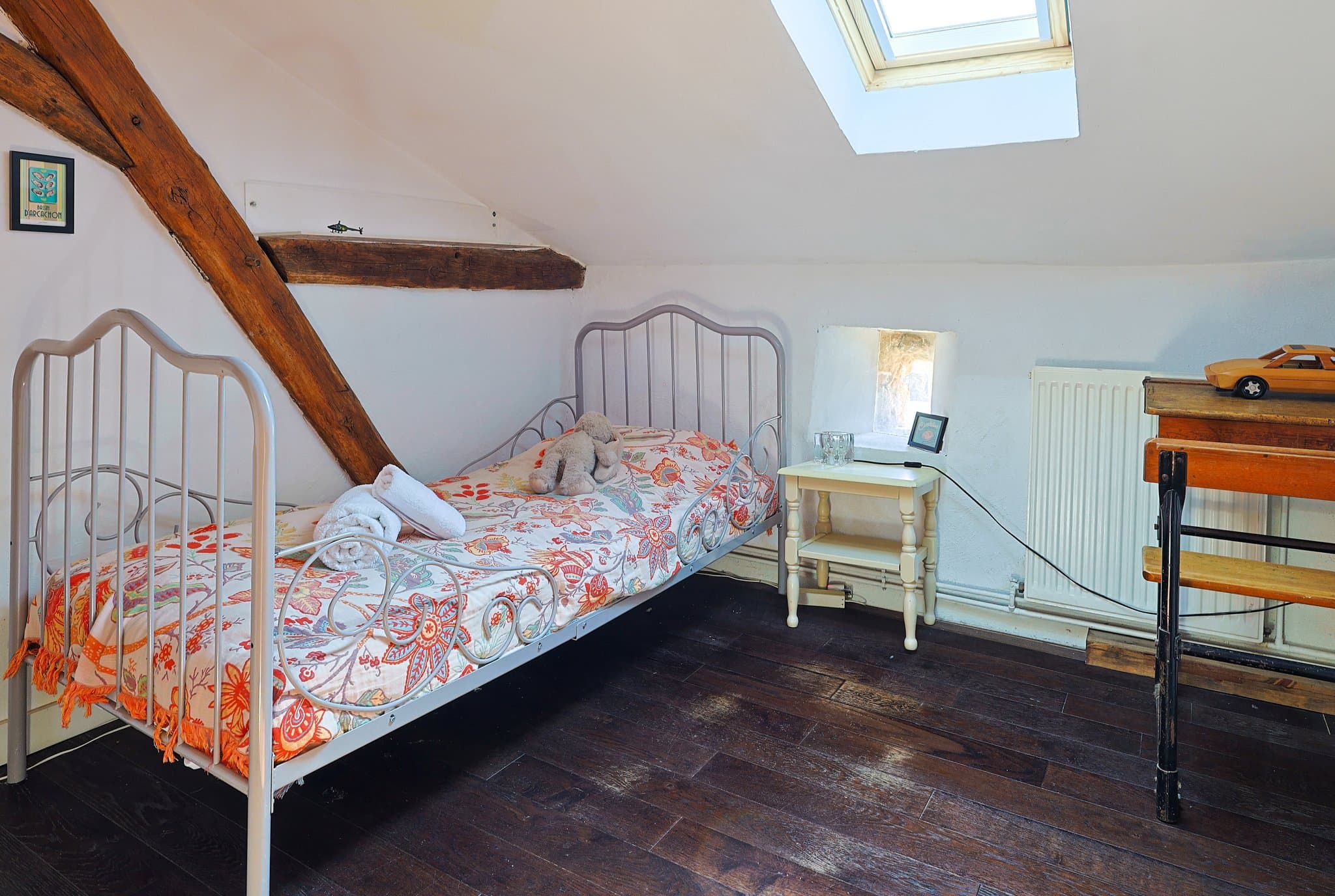 The first-floor children's bedroom at Chez Momône, with its wrought-iron beds beneath the skylight.