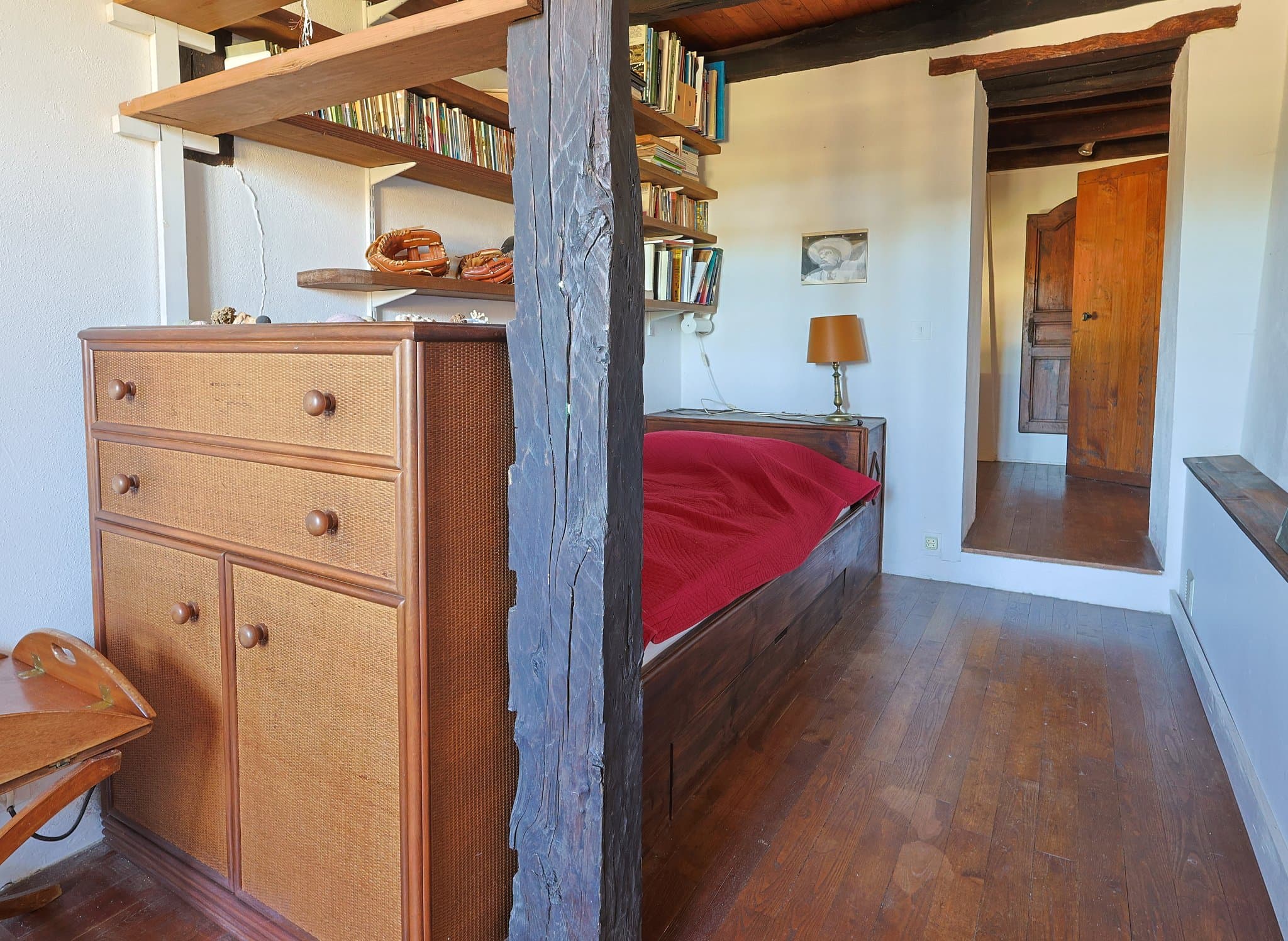 A ground-floor bedroom at Chez Momône, with its antique dresser and red bedspread.
