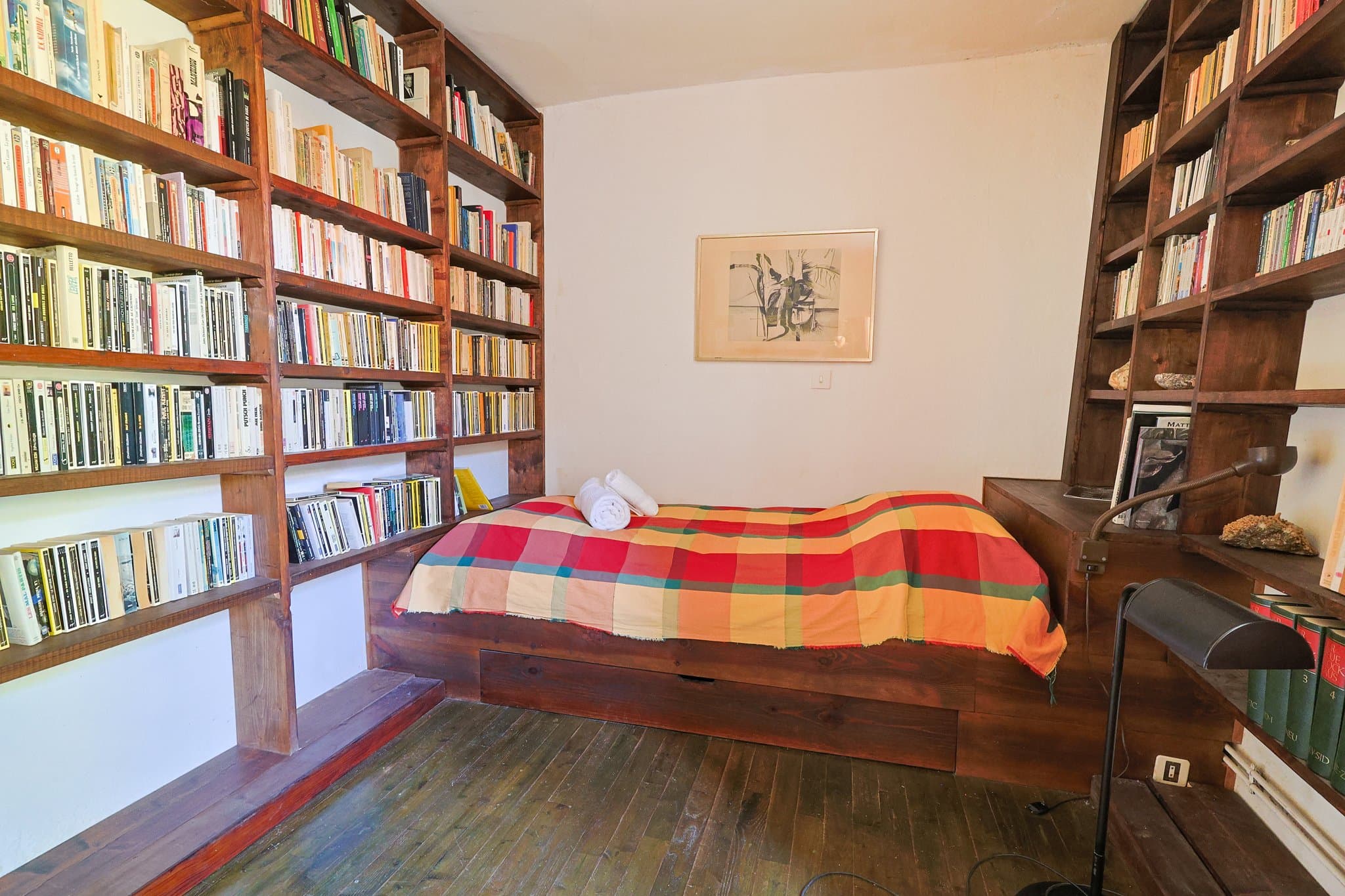A ground-floor bedroom at Chez Momône, lined with bookshelves.