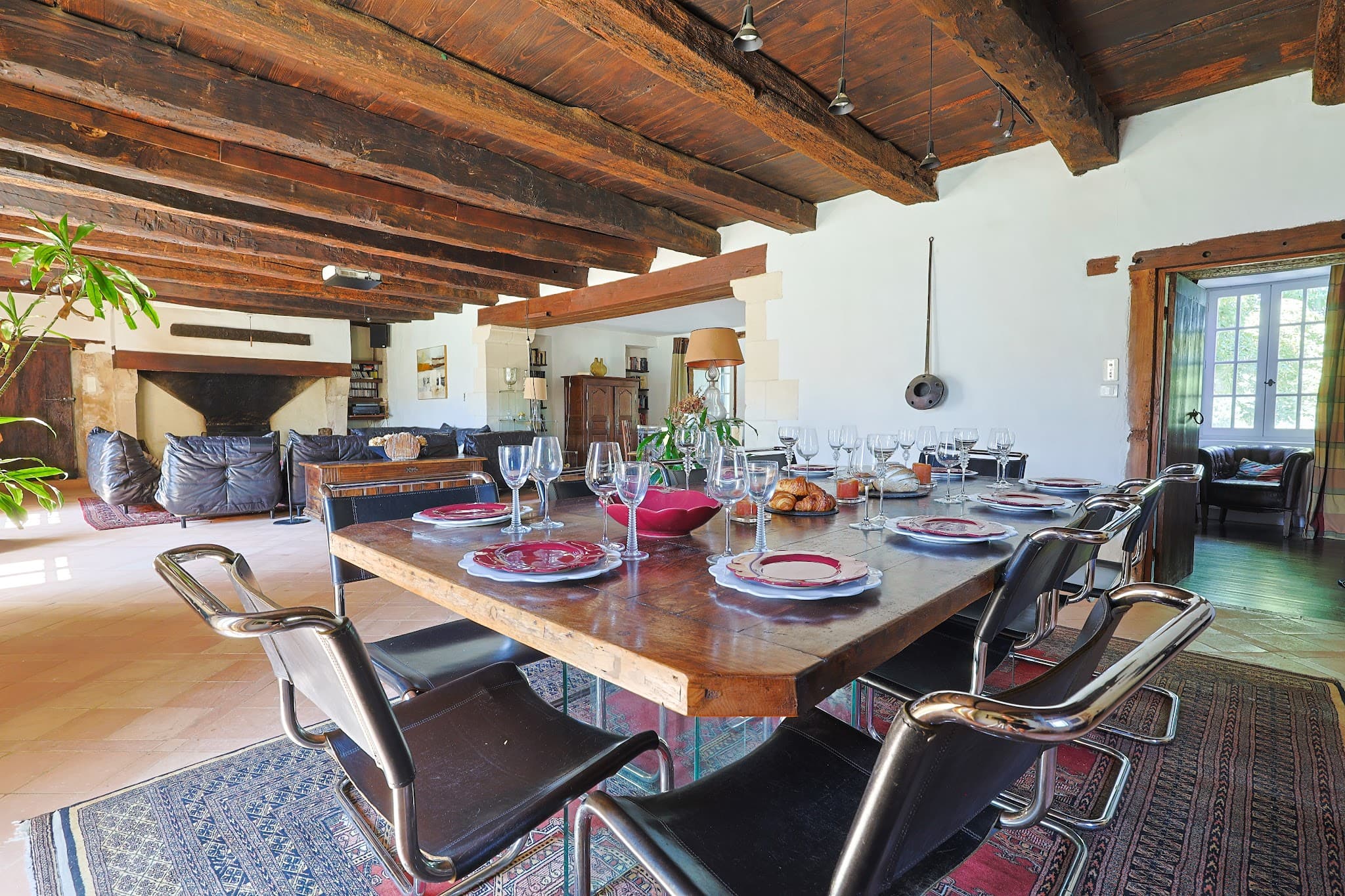 The dining room at Chez Momône: a long table set beneath the beams, opening onto the living room.