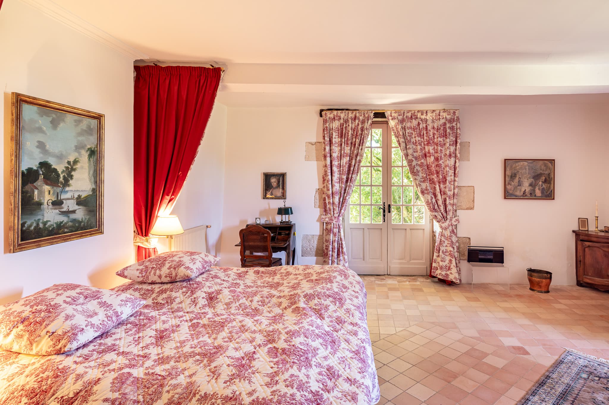 A bedroom in the main house, with its printed fabrics and antique furniture.