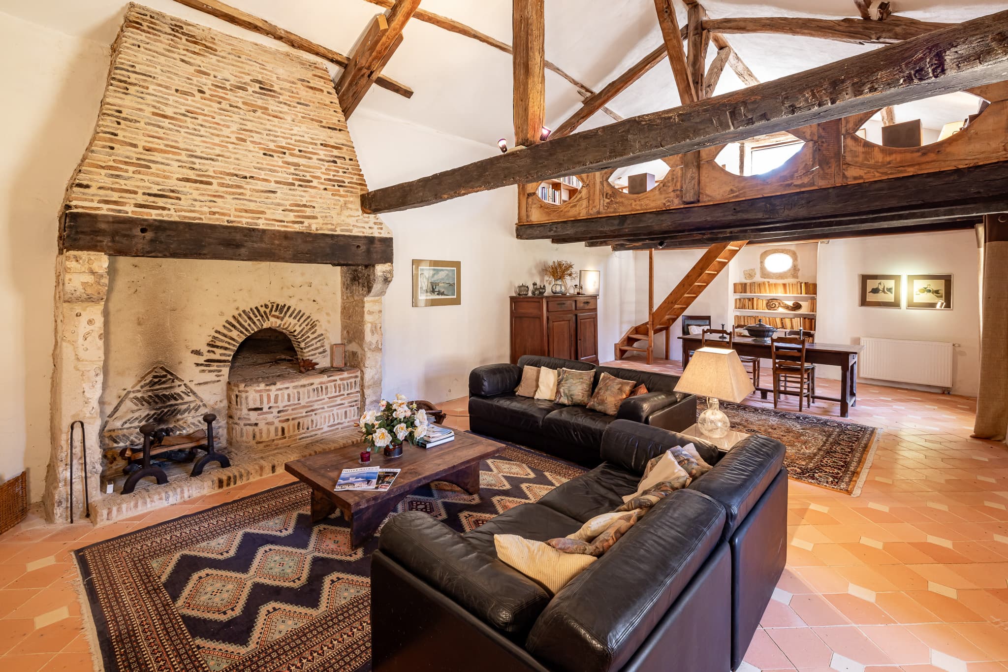 The main house's vaulted living room, with its stone fireplace and exposed beams.